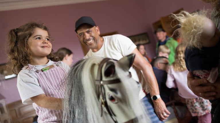A girl playing on the rocking horse in the Nursery at Lanhydrock